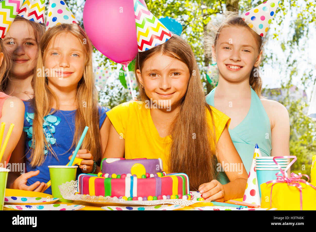 Happy birthday girl in party hat among her friends Stock Photo - Alamy