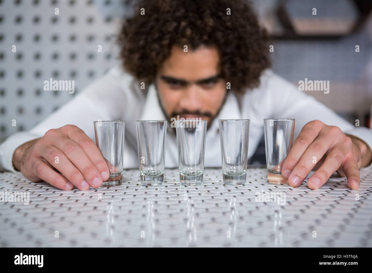 Bartender placing shot glasses on bar counter Stock Photo Alamy
