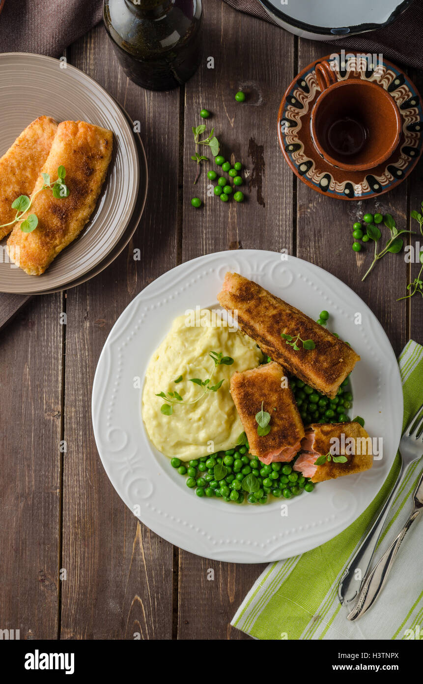 Fried salmon in herb crust with peas and mashed Stock Photo