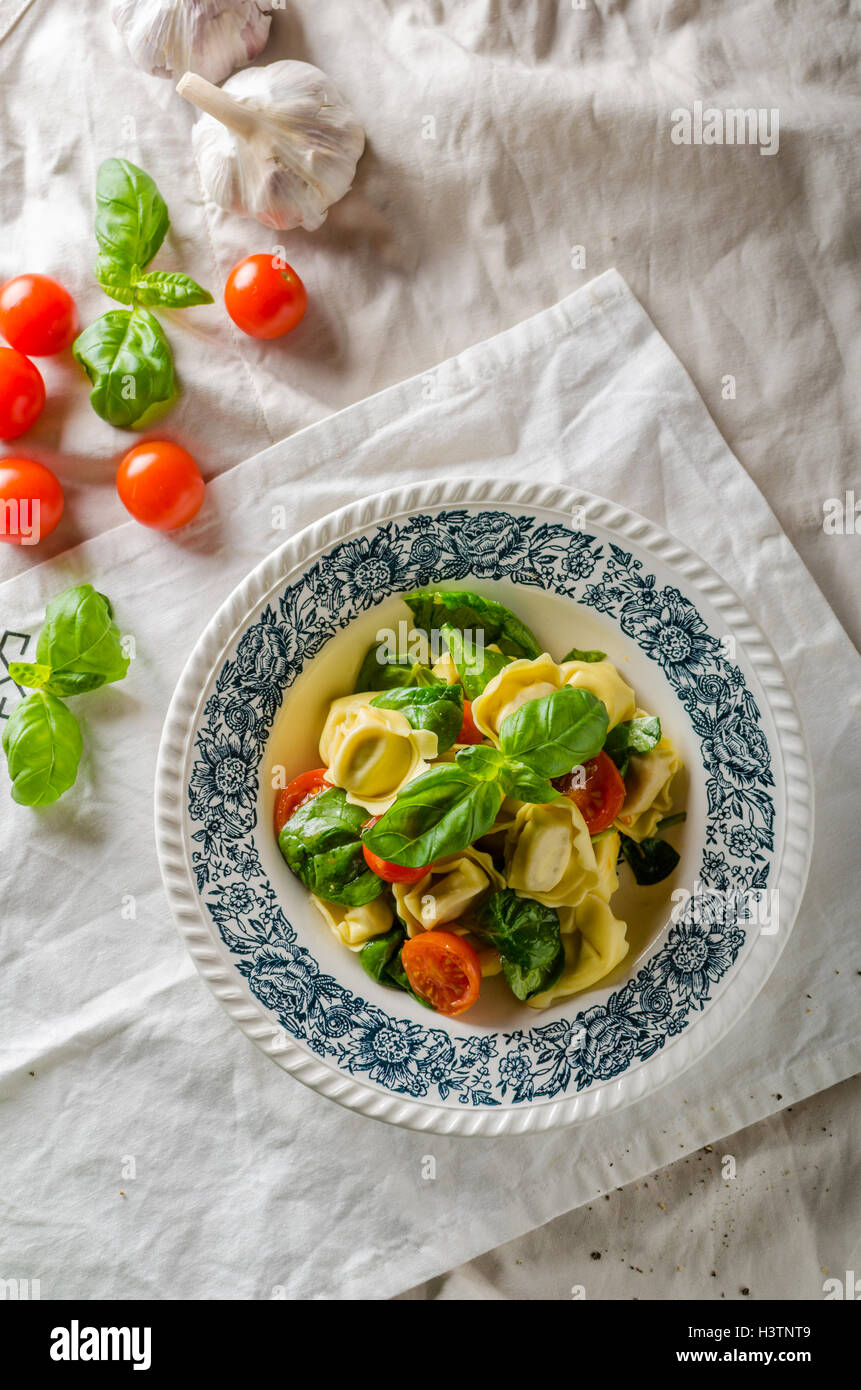 Tortellini stuffed with meat with roasted tomato and basil, olive oil
