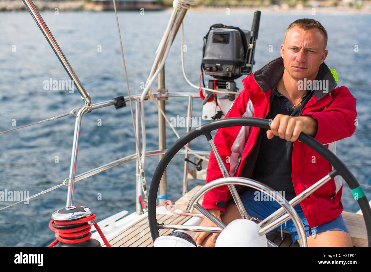 Skipper at the helm controls of a sailing yacht Stock Photo Alamy
