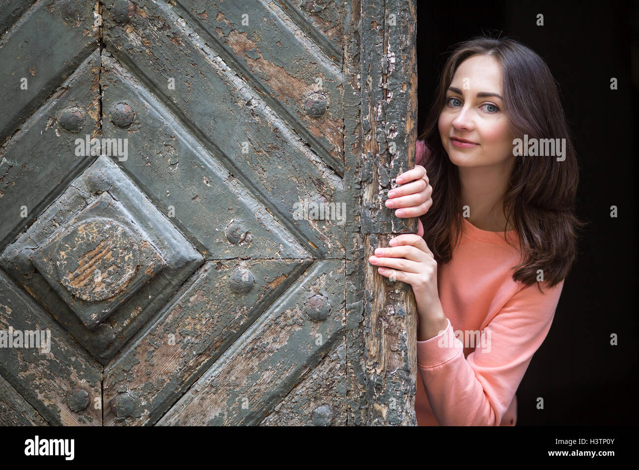 Young woman peeking out door hires stock photography and images Alamy