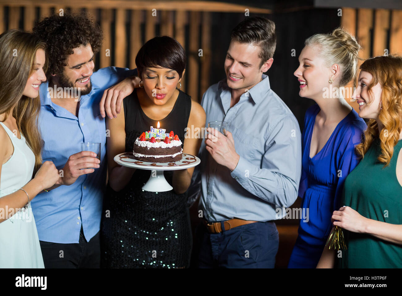 Woman blowing the candle on her birthday cake Stock Photo - Alamy
