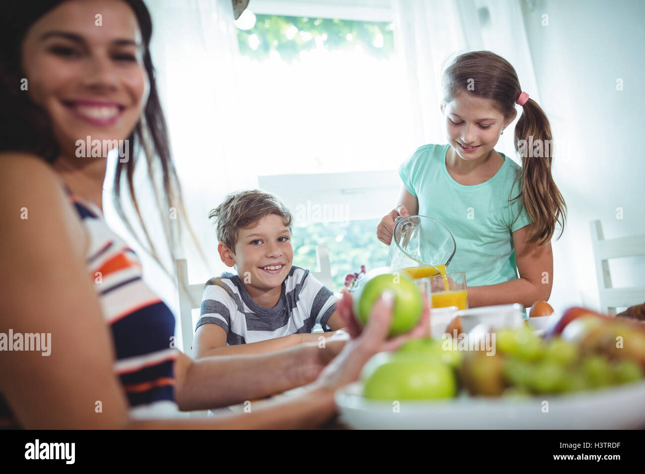 Smiling family having a breakfast Stock Photo - Alamy
