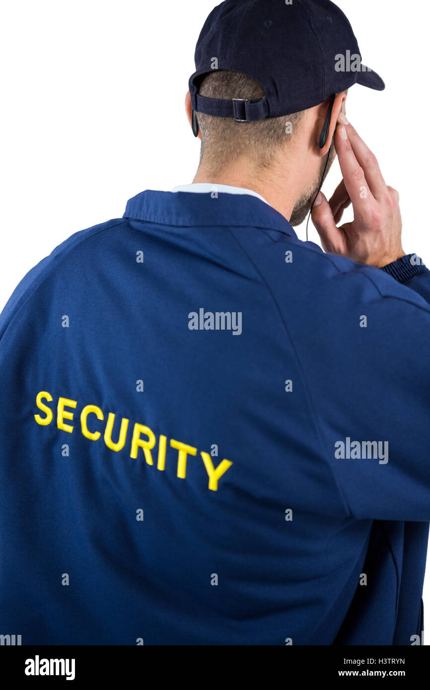 Rear view of security officer listening to earpiece Stock Photo