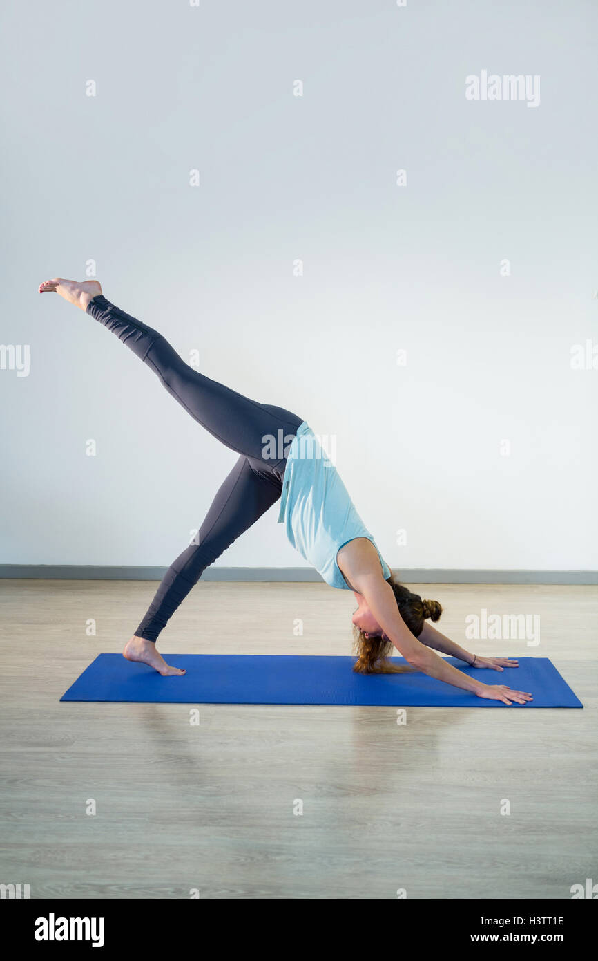 Woman performing yoga on exercise mat Stock Photo - Alamy