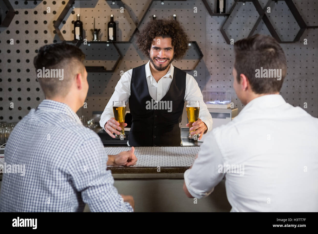 Bartender serving beer to customers Stock Photo Alamy