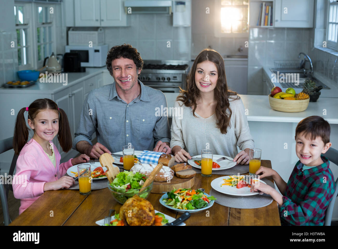 Portrait of happy family having breakfast Stock Photo - Alamy