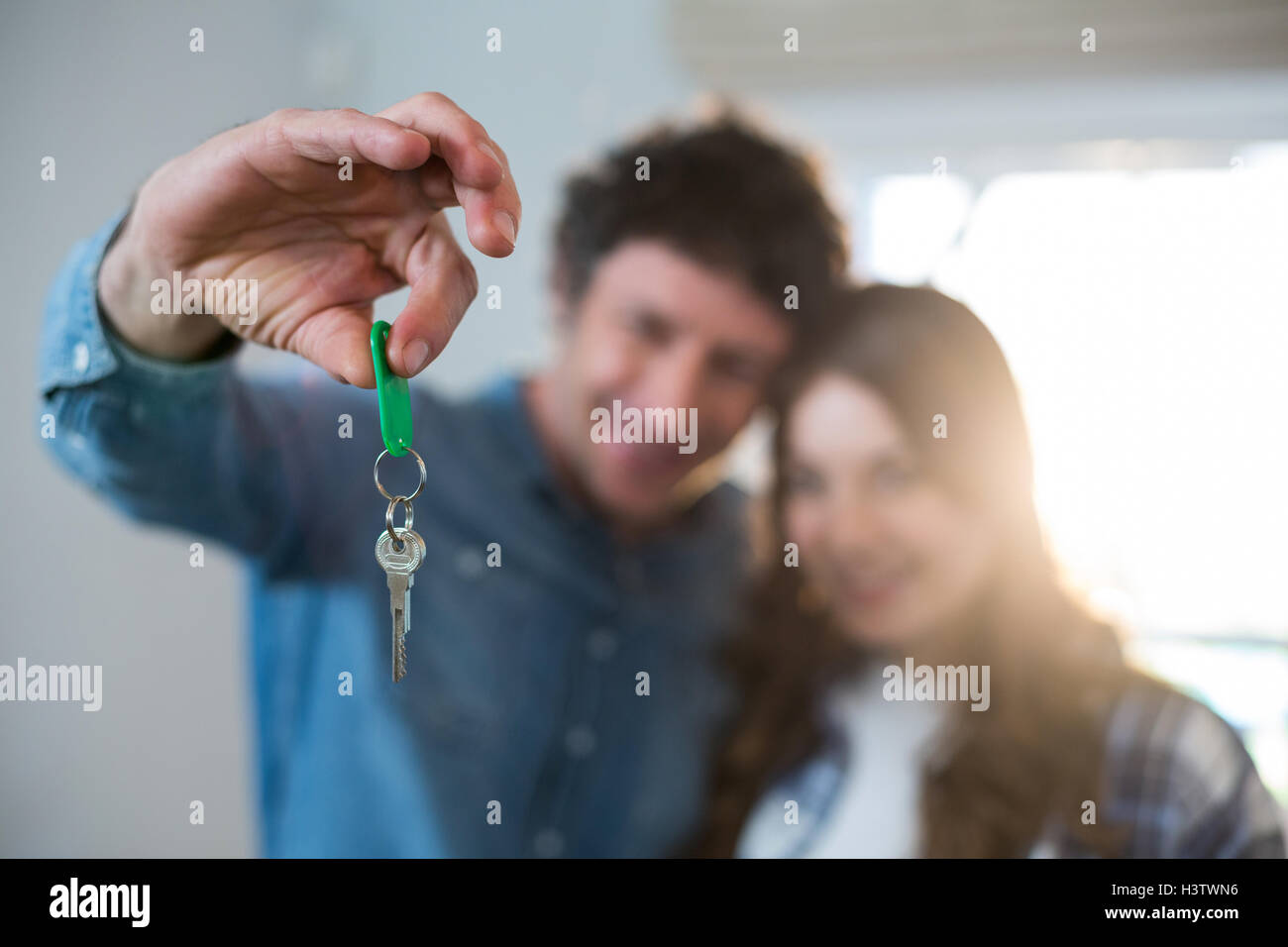 Couple holding the key of new home Stock Photo - Alamy