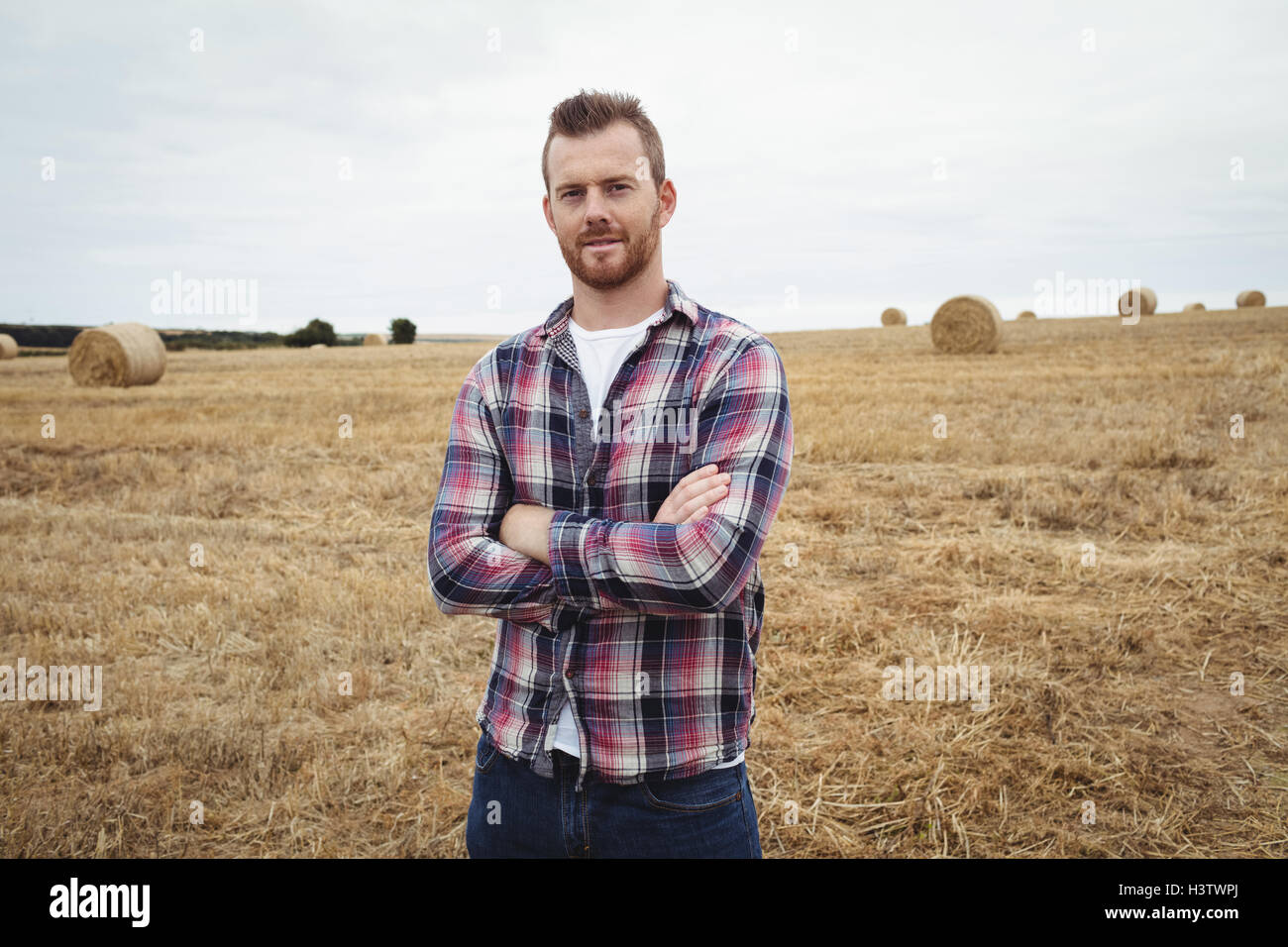 Portrait of farmer standing with arms crossed in the field Stock Photo ...