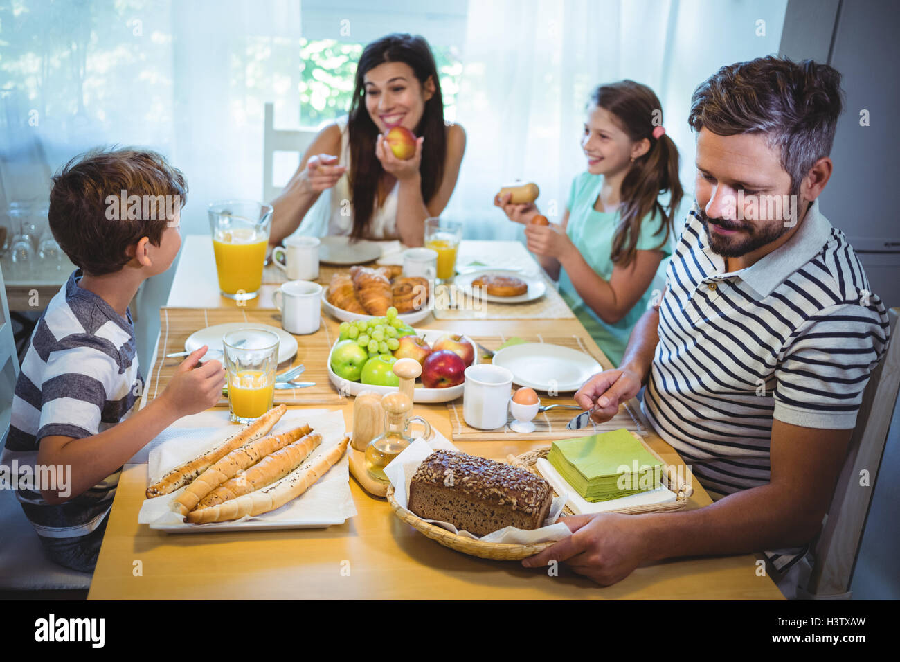 Семья дома. Сток картинки завтрак мужчина ест. Doctor having breakfast. Взрослая девушка с мамой и папой завтракают. While having breakfast.