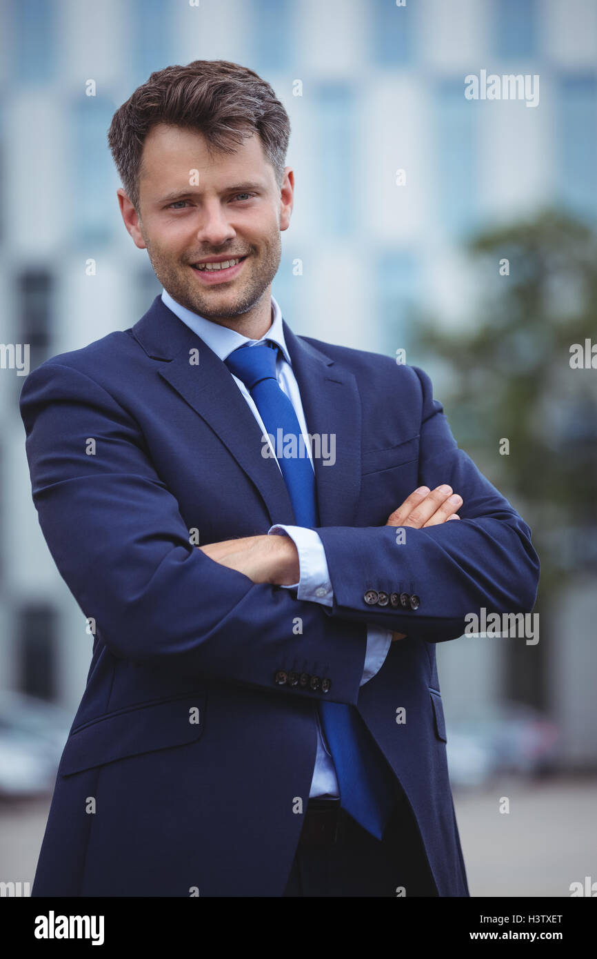 Portrait of handsome businessman standing with arms crossed Stock Photo ...