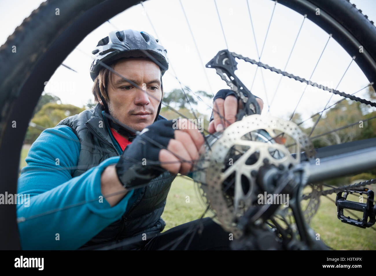 Male mountain biker fixing his bike chain Stock Photo - Alamy