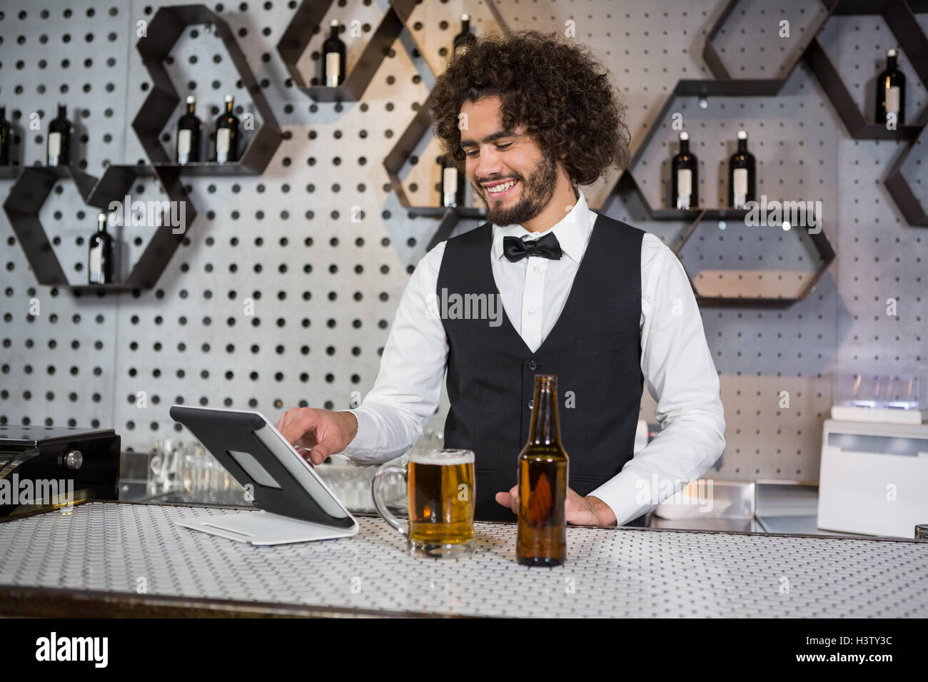 Bartender using digital tablet at bar counter Stock Photo