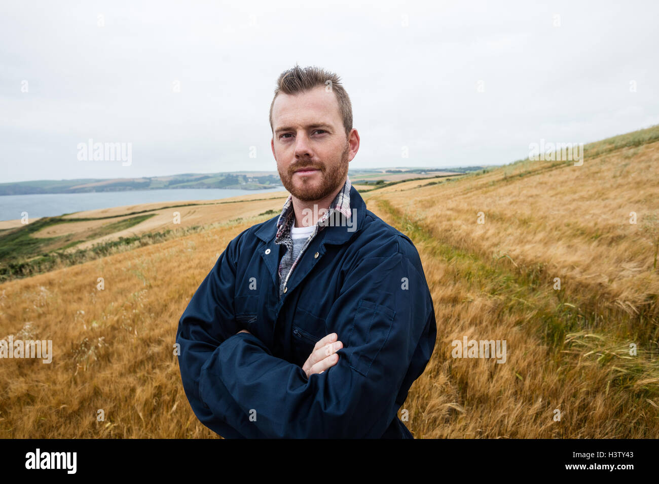 Portrait of farmer standing with arms crossed in the field Stock Photo ...