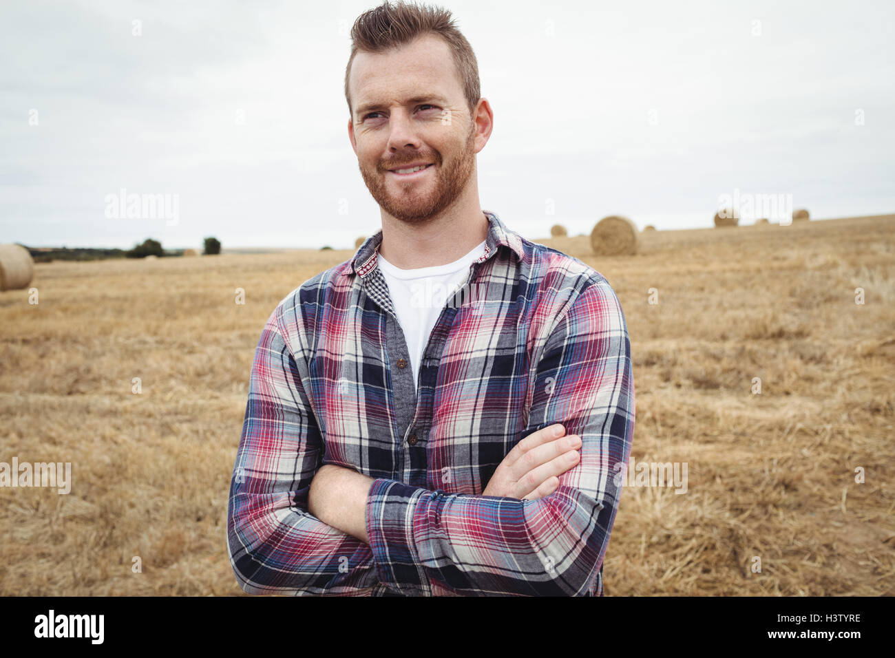 Farmer standing with arms crossed in the field Stock Photo - Alamy