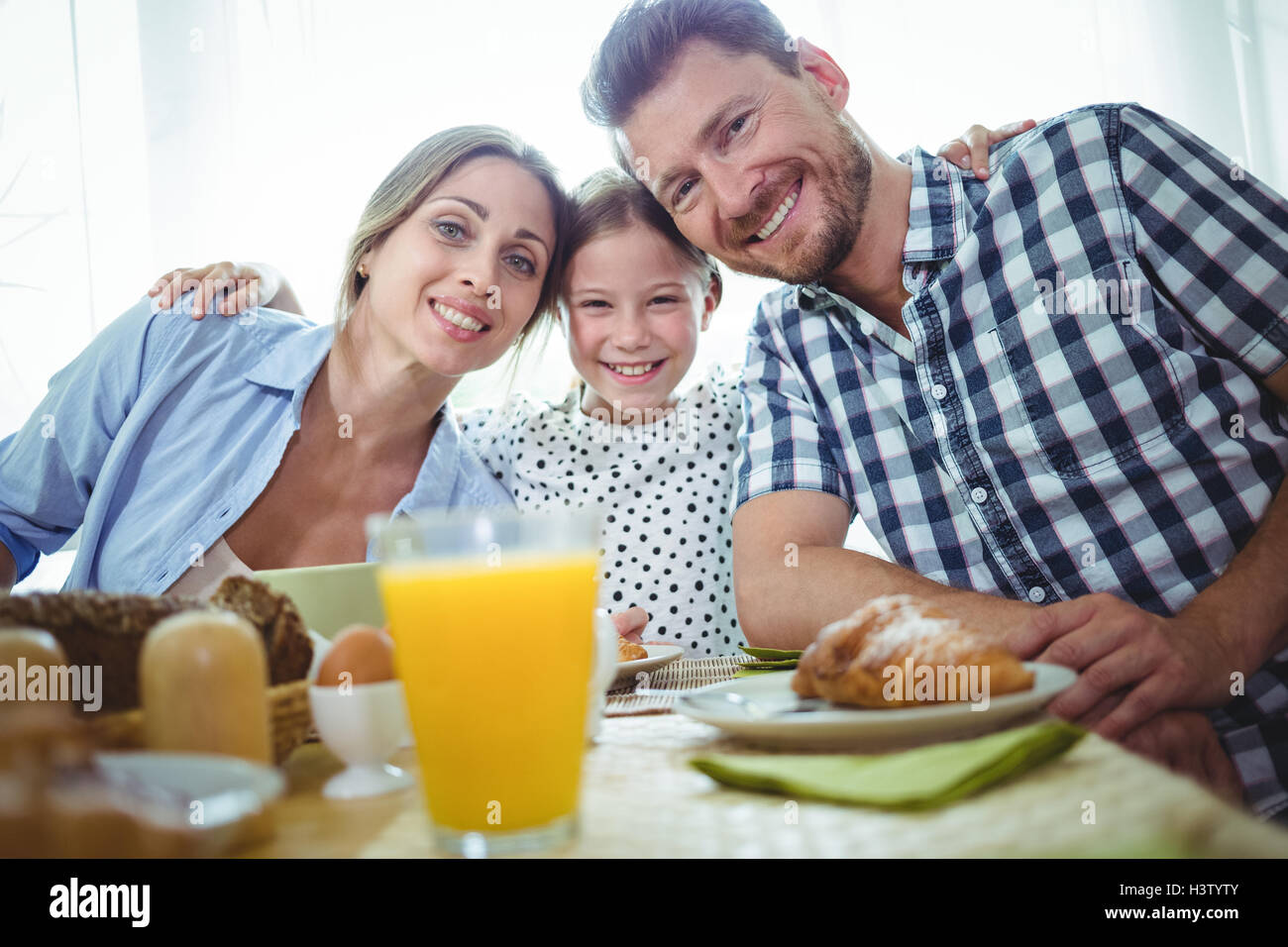 Portrait of happy family having breakfast together Stock Photo - Alamy