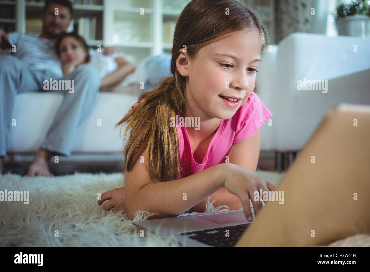 Girl lying on the floor and using laptop Stock Photo - Alamy