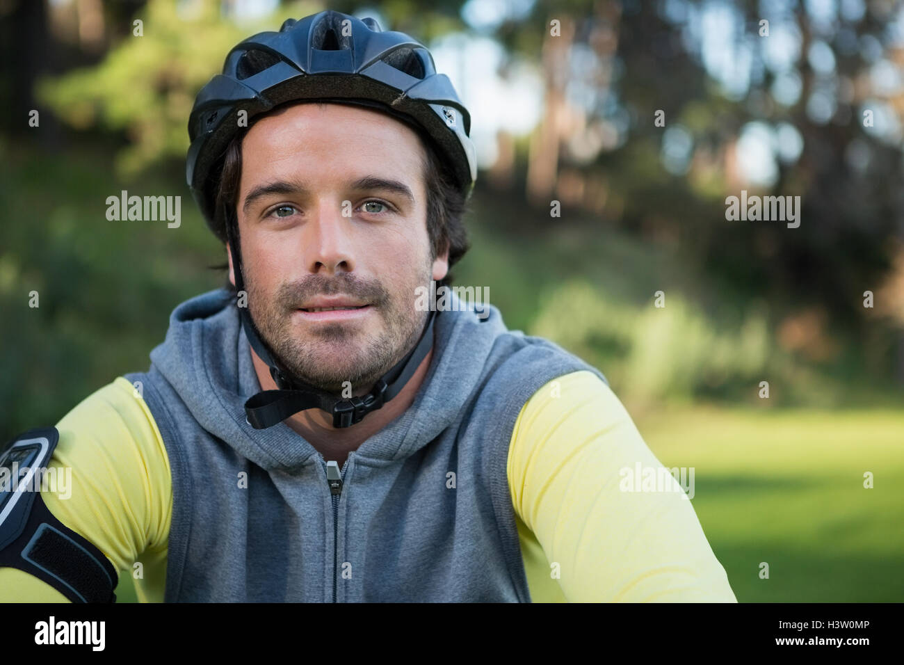 Portrait of male mountain biker riding bicycle in the forest Stock