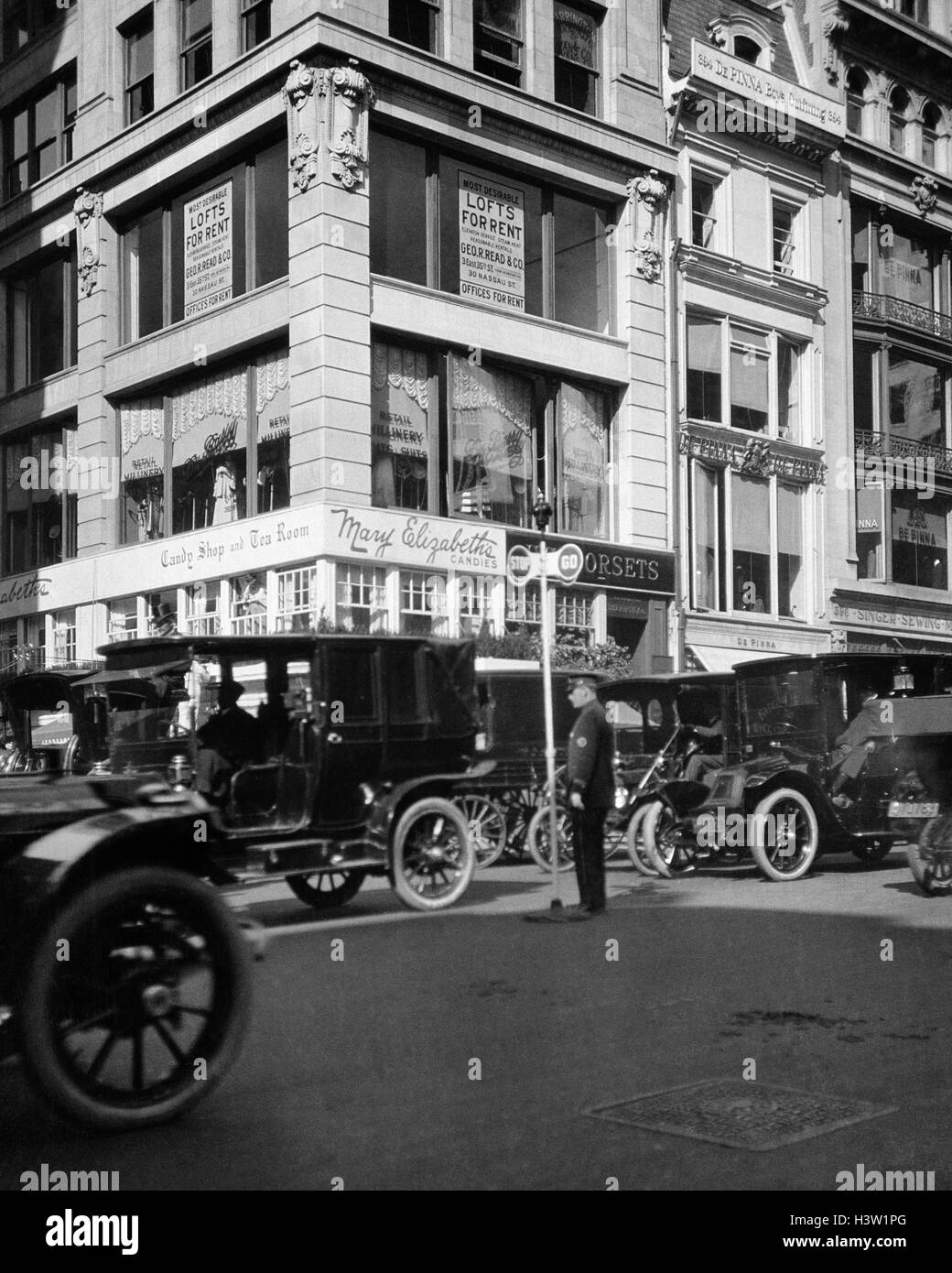 1910s A POLICEMAN CONTROLS TRAFFIC ON FIFTH AVENUE BEFORE WWI USING A HAND OPERATED SEMAPHORE SIGNAL NEW YORK CITY USA Stock Photo