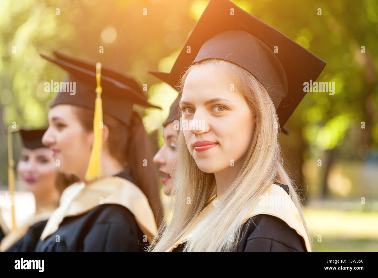Graduate students wearing graduation hat and gown Stock Photo Alamy