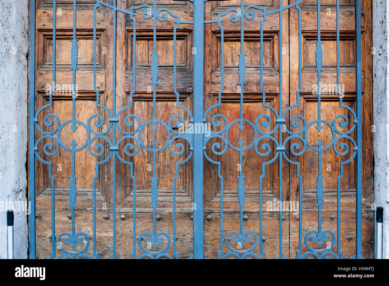 Secured closed main door, building entrance with wooden door and wrought iron gate Stock Photo