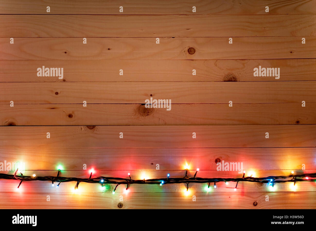 Christmas light boarder on wooden background. Stock Photo