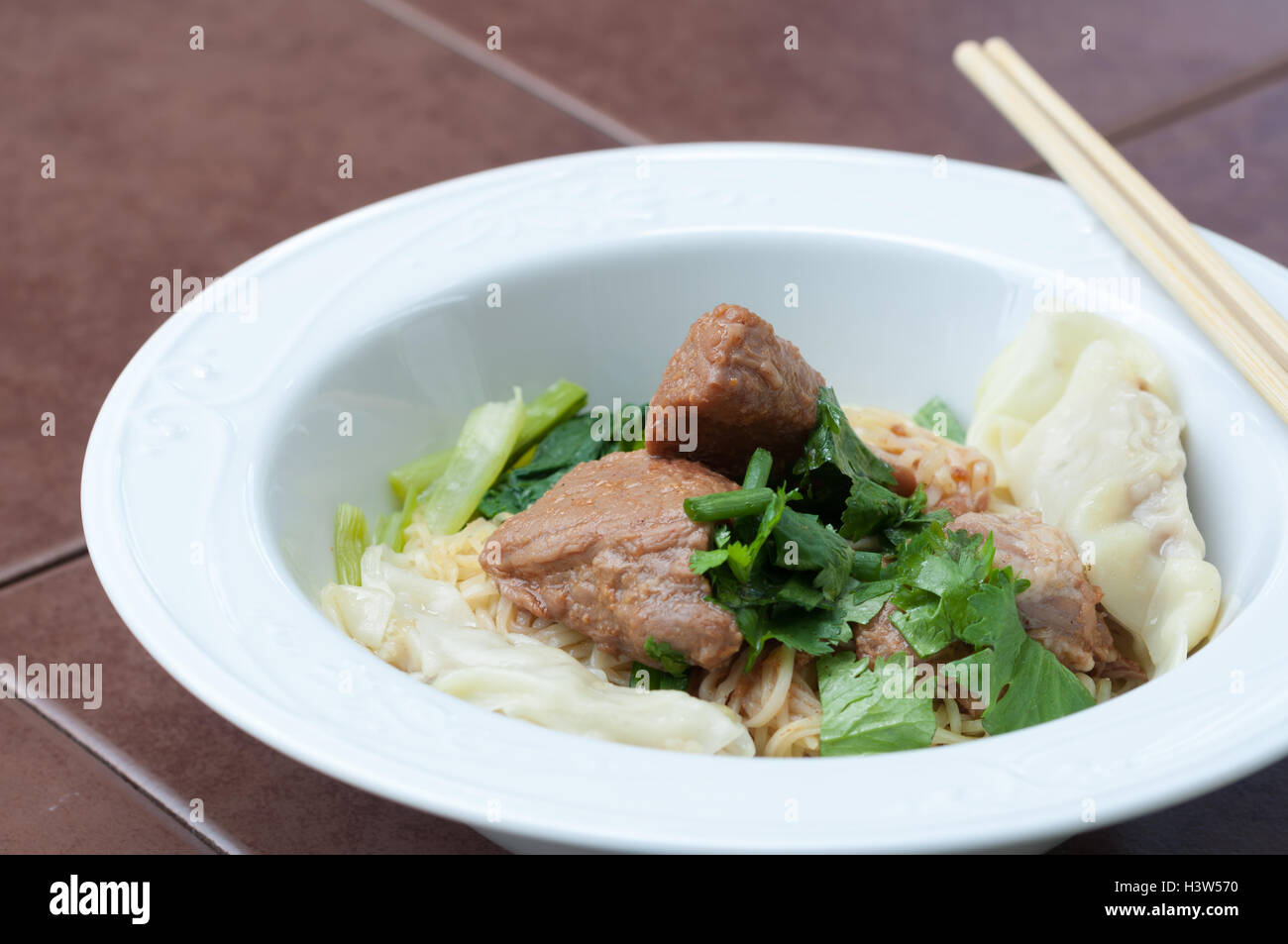 Egg noodle with delicious stewed pork and dumpling, closed up. Stock Photo