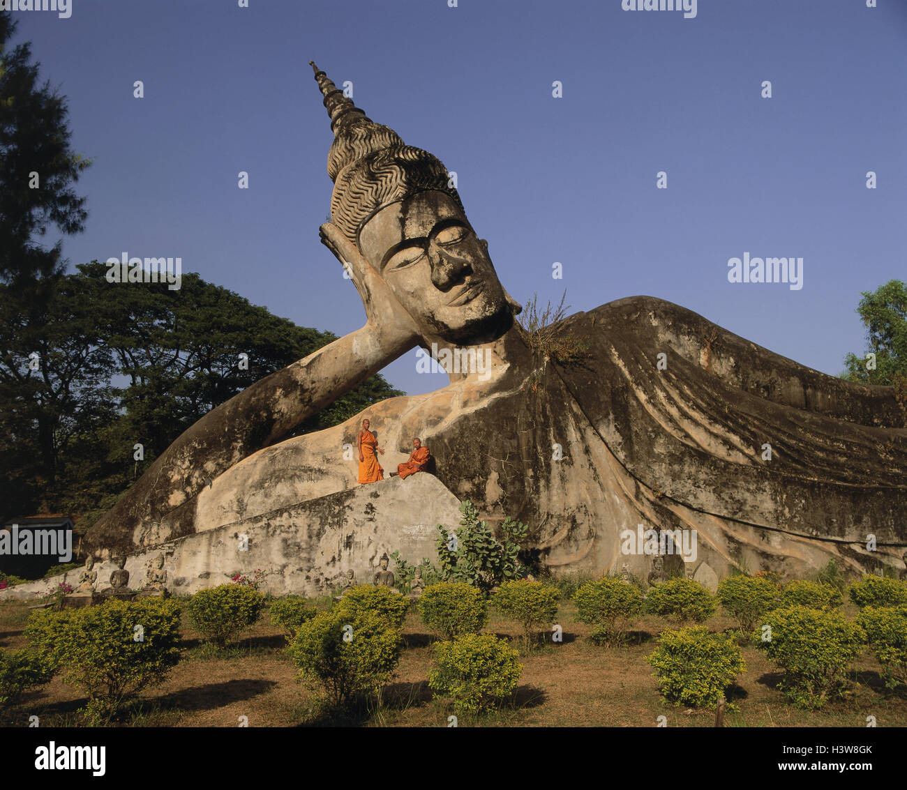 Laos, Vientiane, Wat Xieng Khouan Buddha Park, horizontal Buddha-Statue, detail, monks, outside Stock Photo