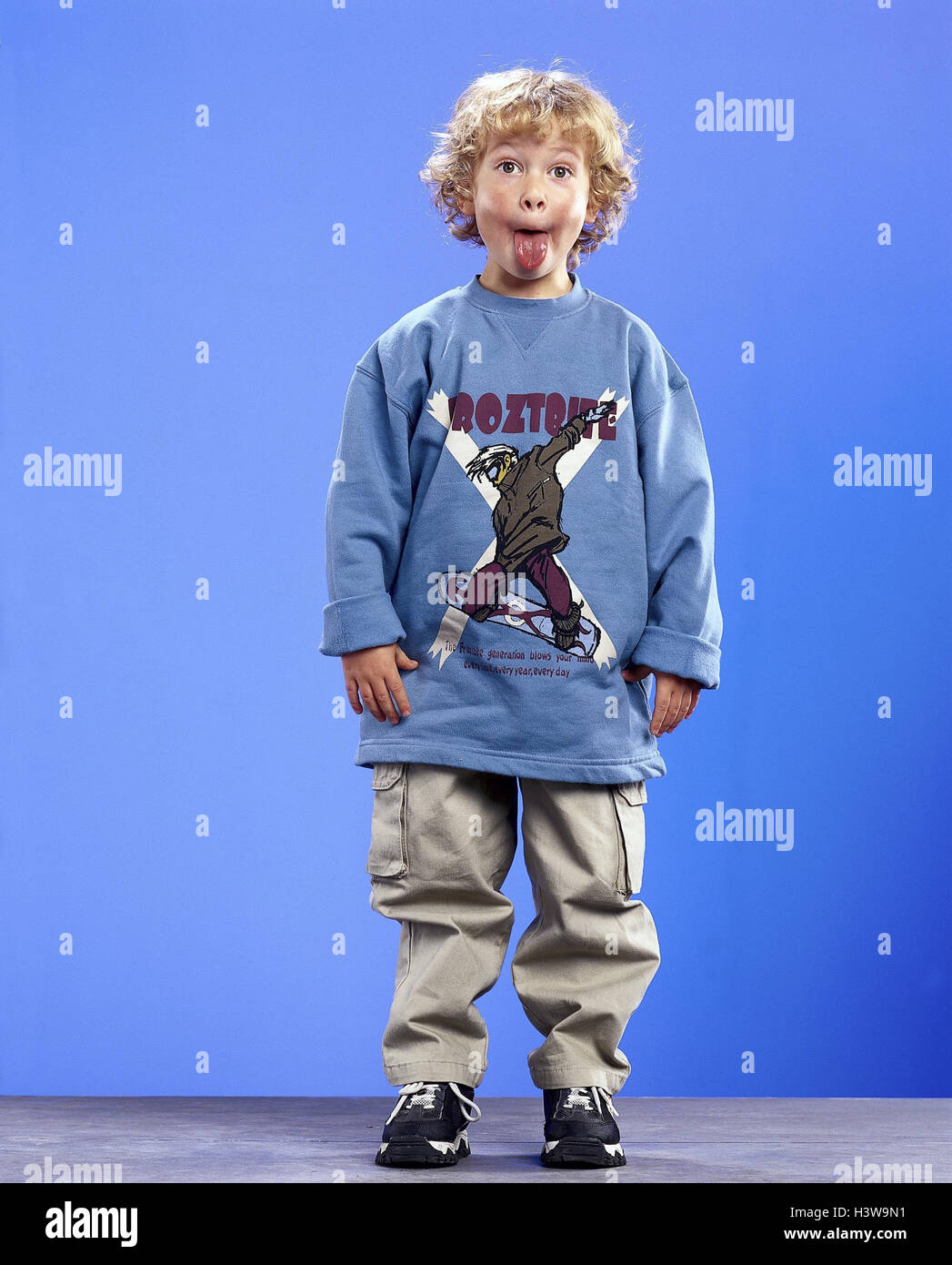 Boy, blond, stand, tongue, Rau's passages, Children, child, cheeky, boorishly, naughtily, education, antiauthoritarian, impertinently, impolitely, coarse, studio, Stock Photo