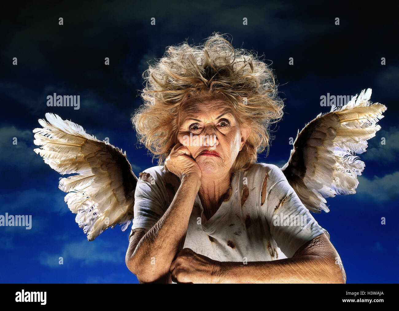Senior, angel, facial play, nastily, fiercely, portrait, studio, 'of fallen angels', woman, old, wing, white, pulls to pieces, unkemptly, dilapidatedly, old, annoyance, discontent, background blue Stock Photo