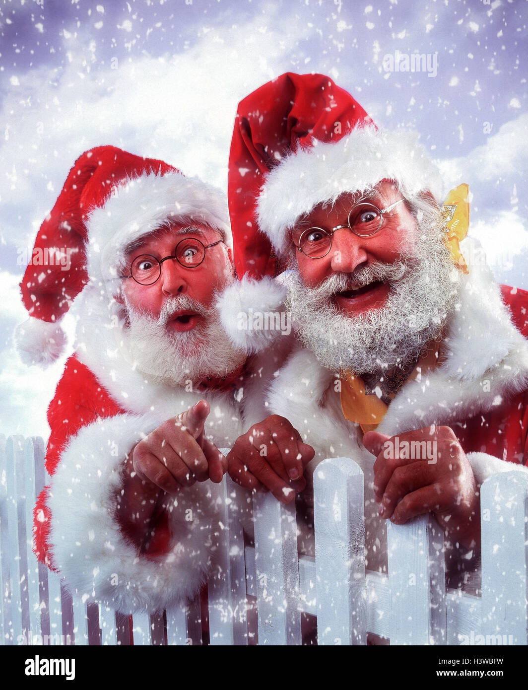 Santas, garden fence, gesture, snowfall Santa Claus, two, Santa, glasses, tip, interpret, point, facial play, surprise, surprises, is surprised, amazed, enthusiasm, enthusiastically, discovery, snow, studio Stock Photo