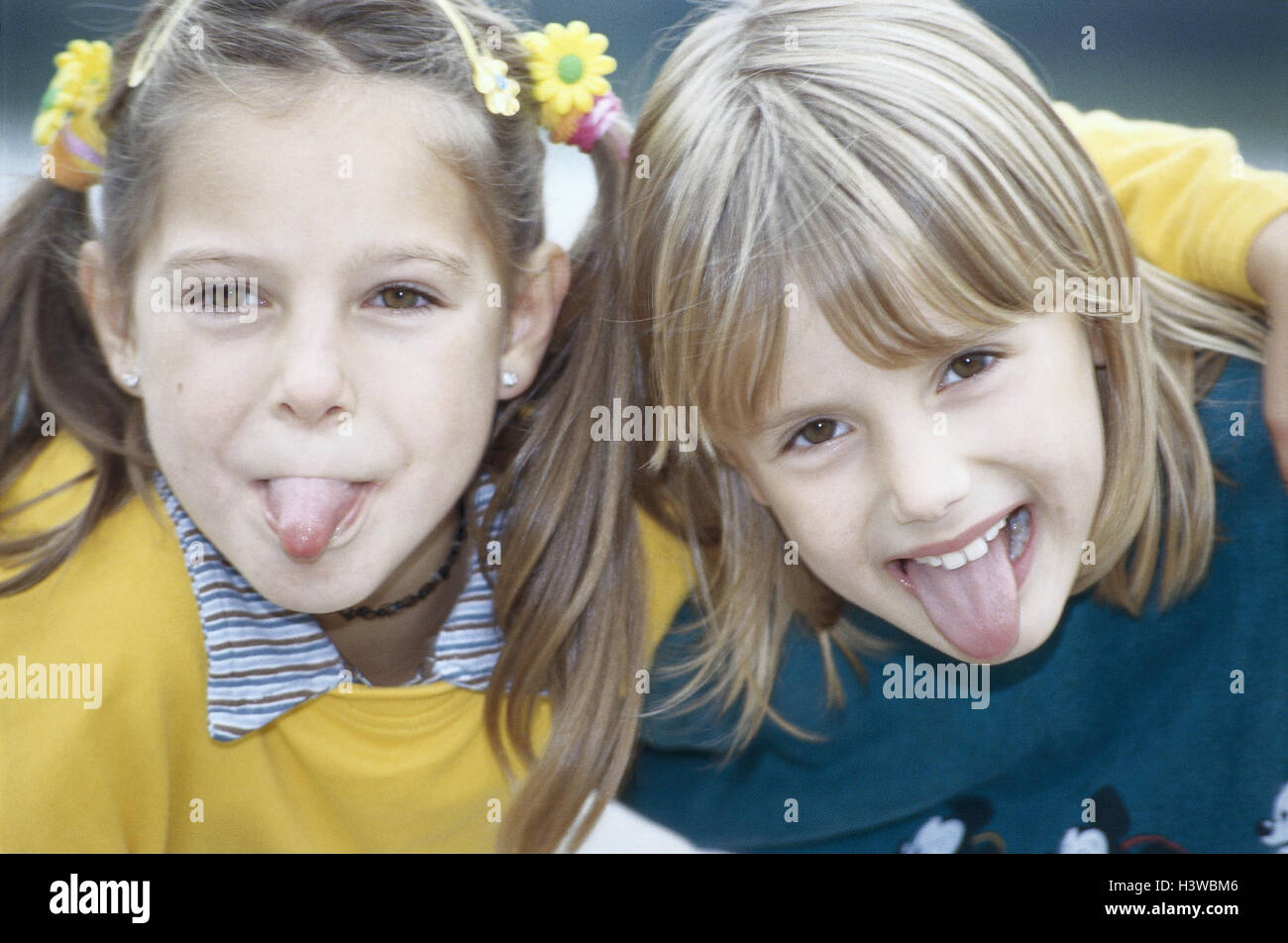 Girls, two, gesture, cheeky, tongue, stick out, portrait, outside, children, disobediently, insults, education, impertinently, naughtily Stock Photo