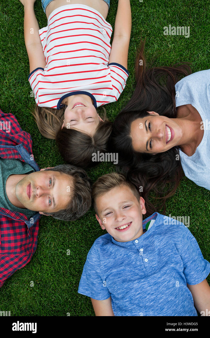 Happy family lying on grass in park Stock Photo - Alamy