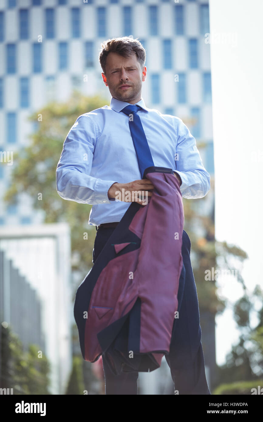 Portrait of handsome businessman holding blazer Stock Photo - Alamy