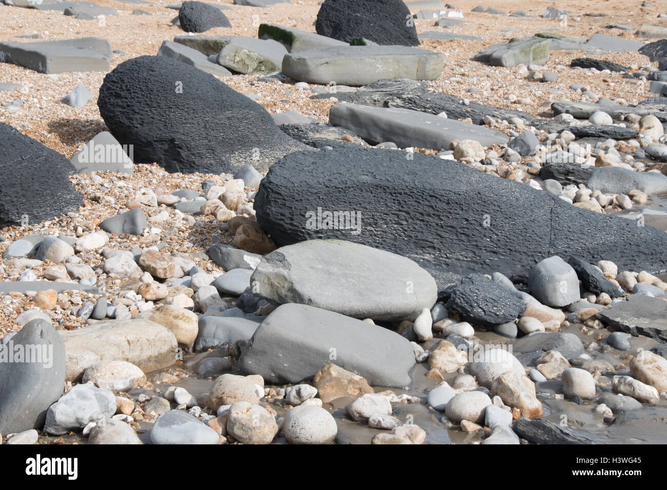 Assorted rock on the seashore at Charmouth, Dorset, part of the Jurassic coastline. Stock Photo