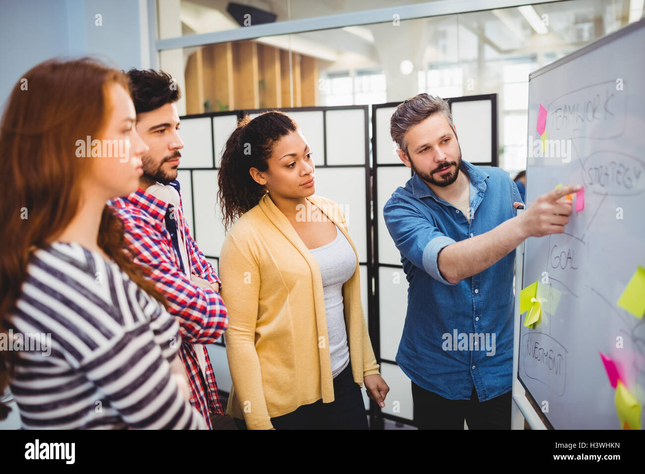 Executive explaining strategy on whiteboard in creative office Stock ...