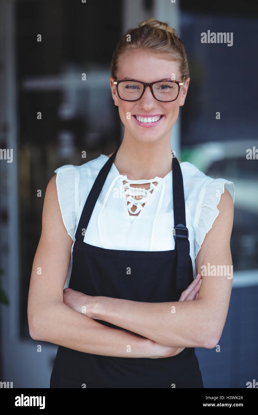 Portrait of smiling waitress standing with arms crossed Stock Photo - Alamy