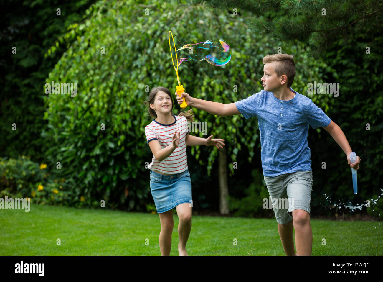 Kids playing with bubbles in the park Stock Photo - Alamy