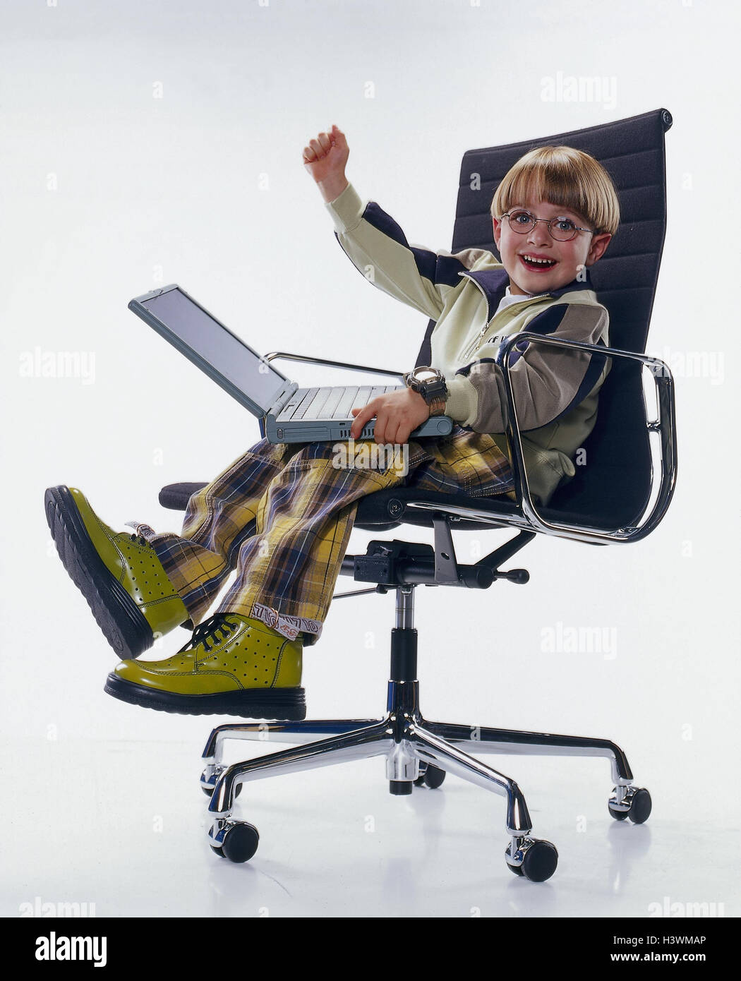 Boy, career plans, computer expert, programmers, office chair, sit, notebook computer, gesture, enthusiasm, professions, laptop, computer, joy, child as an adult, cut out, studio, childhood dream Stock Photo