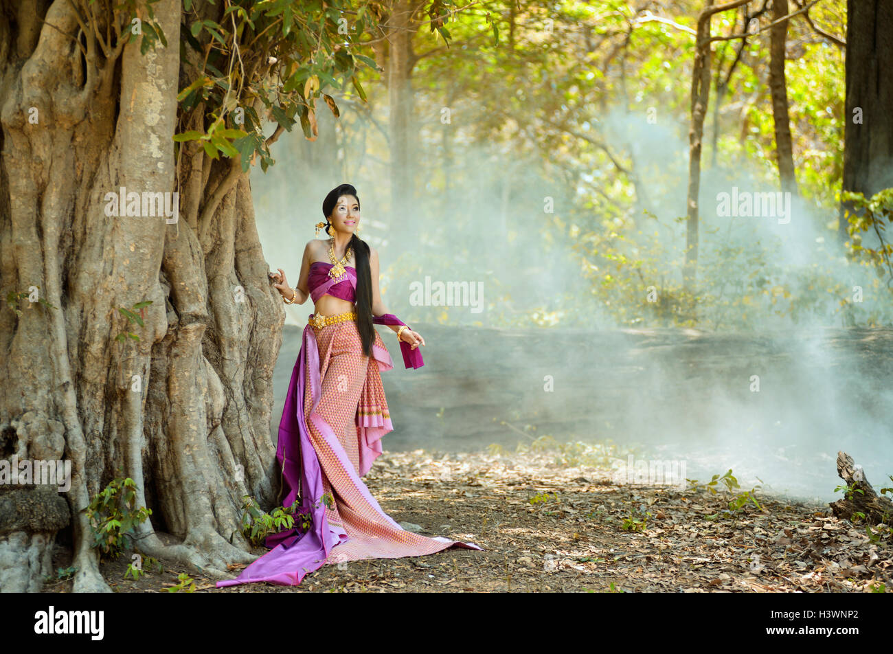 Woman standing in forest wearing traditional clothing, Thailand Stock Photo