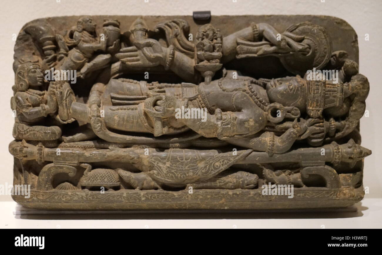 Carved statue of the God Vishnu laying over the cosmic serpent Shesha. Dated 14th Century Stock Photo