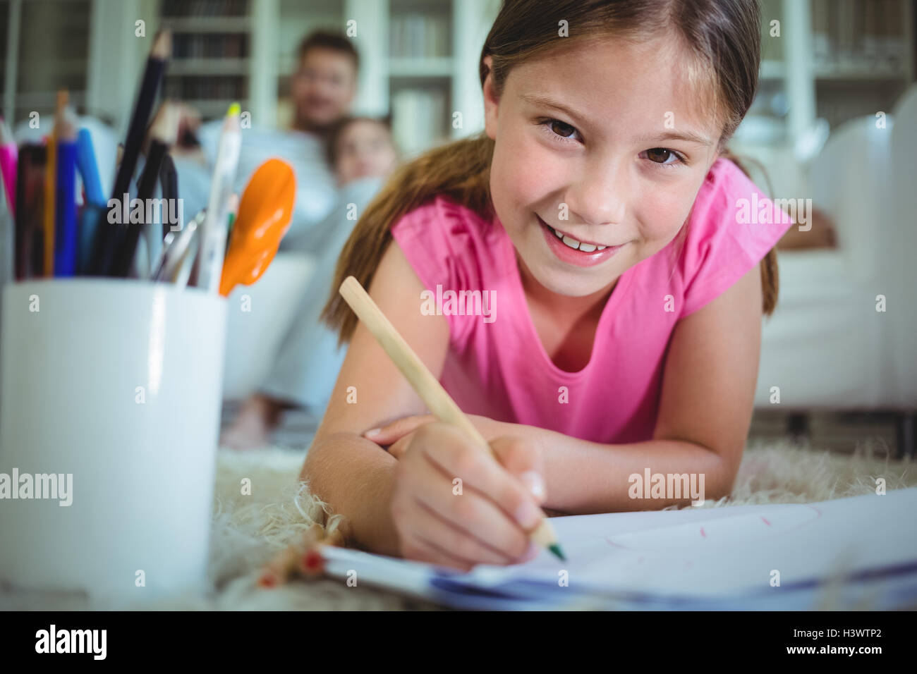 Girl lying on the floor and drawing Stock Photo - Alamy