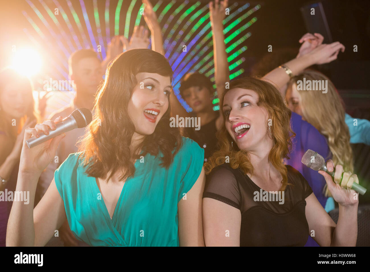 Two beautiful women singing song together Stock Photo