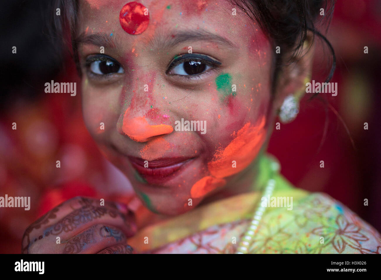 Dhaka, Bangladesh. 11th October, 2016. Bangladeshi Hindu devotees put vermillion and color on each other's faces as they dance on the final day of the Durga Puja Festival in Dhaka, Bangladesh, on October 11, 2016. The five-day Durga Puja festival commemorates the slaying of a demon king Mahishasur by Hindu goddess Durga, marking the triumph of good over evil. Credit:  zakir hossain chowdhury zakir/Alamy Live News Stock Photo