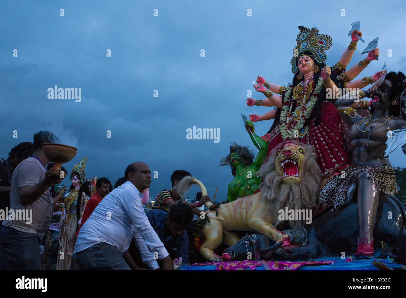 Dhaka, Bangladesh. 11th October, 2016. Bangladeshi Hindu devotees immerse an idol of Hindu Goddess Durga into the river Buriganga in Dhaka, Bangladesh, on October 11, 2016. The five-day Durga Puja festival commemorates the slaying of a demon king Mahishasur by Hindu goddess Durga, marking the triumph of good over evil. Credit:  zakir hossain chowdhury zakir/Alamy Live News Stock Photo