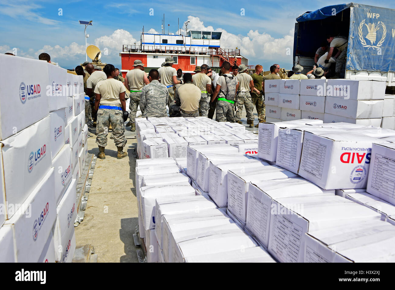 U.S service members unload humanitarian relief supplies from a ship to aid those affected by Hurricane Matthew October 11, 2016 in Port-au-Prince, Haiti. Hurricane Matthew struck Haiti with winds over 140-mph killing 500 people and causing widespread damage. Stock Photo