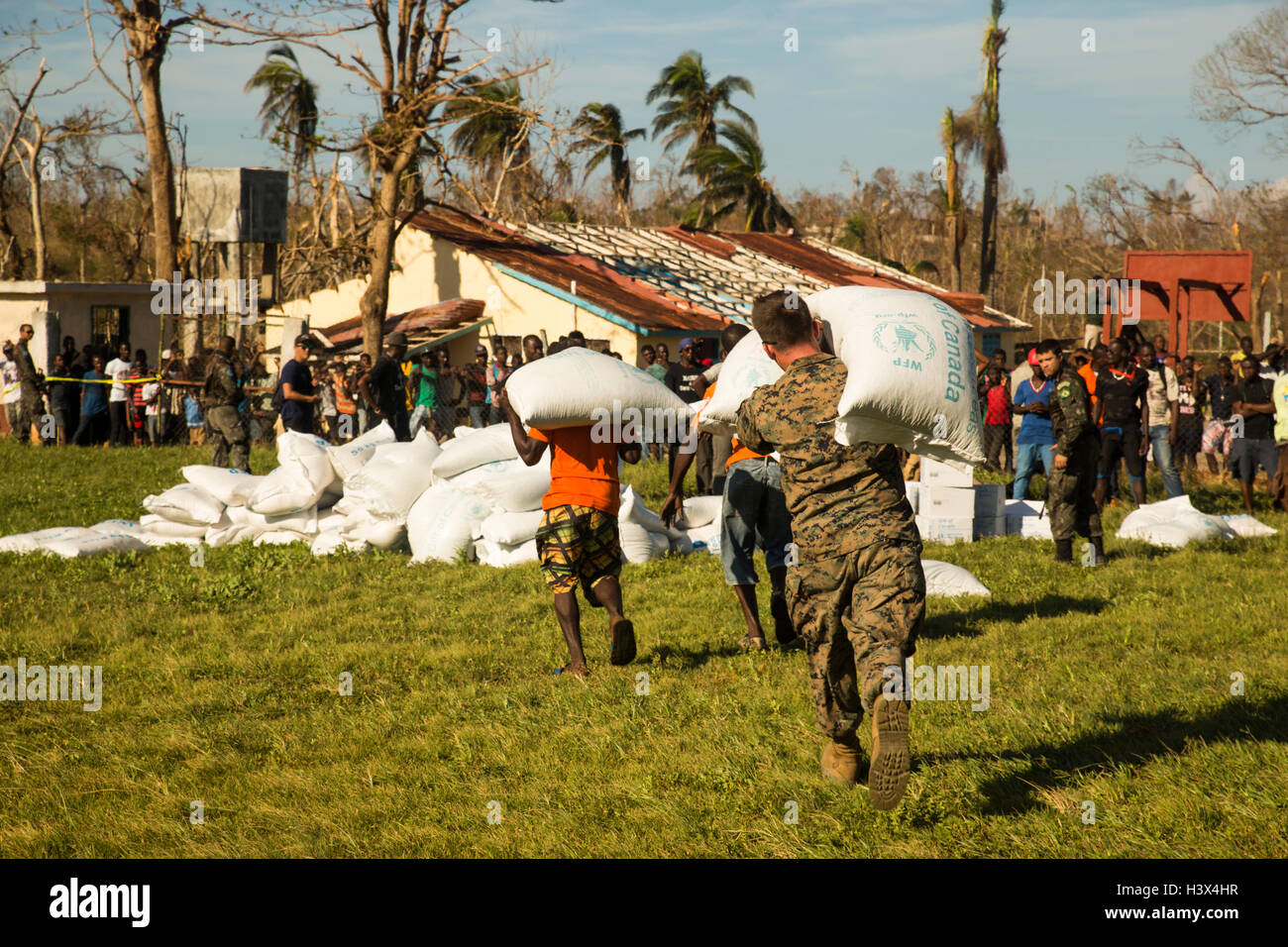 Dame Marie, Haiti. 12th October, 2016. U.S Marines assisted by Haitian unload food supplies to aid those affected by Hurricane Matthew October 12, 2016 in Dame Marie, Haiti. Hurricane Matthew struck Haiti with winds over 140-mph killing 500 people and causing widespread damage. Credit:  Planetpix/Alamy Live News Stock Photo