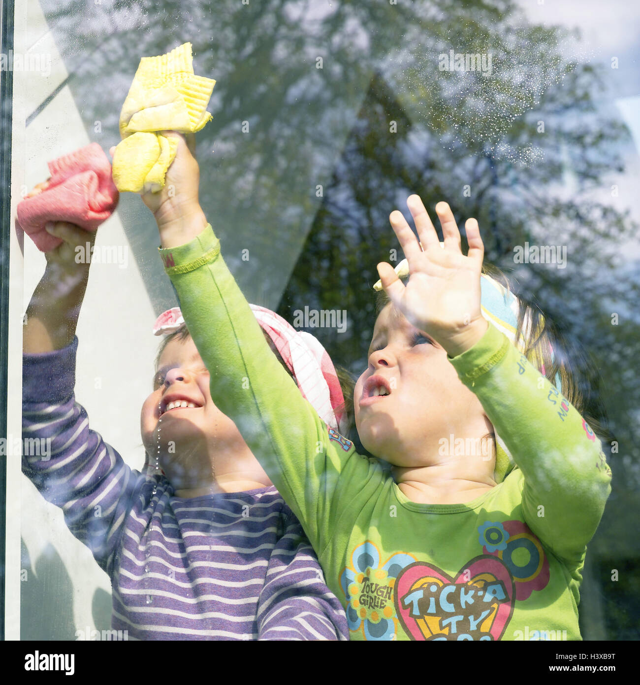 Children, girls, windows clean, detail, twins 3 years, sisters, siblings, friends, friendship, childhood, housecleaning, window plaster, 'cleaning devil', cloths, fungus cloths, windowpane, clean, dry, together, cohesion, community, motivation, ambition, Stock Photo