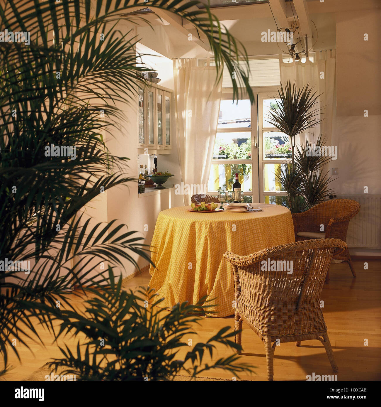 Loft, living space, dining room, flat, inside, interior shot, dining table, wicker armchair, indoor plants, Arecapalme, sword fern, dragon's tree, product photography Stock Photo